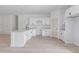 Modern kitchen with island, white cabinets, sleek countertops, stainless steel sink, and bright laminated floors at 55 Laurel Crse, Ocala, FL 34480
