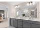 Modern bathroom featuring double sinks, gray cabinets, a quartz countertop, and a large mirror for a sleek design at 5511 Flame Vine Way, St Cloud, FL 34771