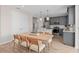Open concept dining area with a wooden table, gray cabinets, and stainless steel appliances in the kitchen at 5511 Flame Vine Way, St Cloud, FL 34771
