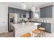 Contemporary kitchen with stainless steel appliances, an island, gray cabinetry, and modern pendant lights at 5511 Flame Vine Way, St Cloud, FL 34771