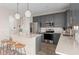 Modern kitchen with gray cabinets, a white countertop island, stainless steel appliances, and pendant lighting at 5511 Flame Vine Way, St Cloud, FL 34771