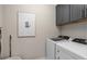 Well-equipped laundry room with modern washer and dryer and ample cabinet space at 5511 Flame Vine Way, St Cloud, FL 34771