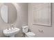 Elegant powder room with a pedestal sink, round mirror, and minimalist wall art at 5511 Flame Vine Way, St Cloud, FL 34771