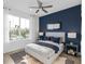 Inviting bedroom featuring a plush bed, blue accent wall, and bright natural light from a large window at 5517 Flame Vine Way, St Cloud, FL 34771