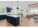 Open-concept kitchen with dark blue cabinets, a white countertop island, and views into the living room at 5517 Flame Vine Way, St Cloud, FL 34771