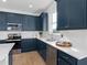 A kitchen featuring stainless steel appliances, white backsplash, and stylish blue cabinetry at 5517 Flame Vine Way, St Cloud, FL 34771