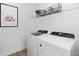 Modern laundry room featuring a front load washer and dryer with overhead shelving at 5517 Flame Vine Way, St Cloud, FL 34771