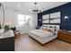 Stylish main bedroom featuring an accent wall, modern light fixture and wood look flooring at 5517 Flame Vine Way, St Cloud, FL 34771