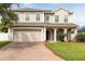 Charming two-story home showcasing a brick driveway, attached two-car garage, and welcoming front porch at 563 Copperdale Ave, Winter Garden, FL 34787