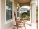 Covered front porch features classic rocking chairs, creating a cozy and inviting entryway at 563 Copperdale Ave, Winter Garden, FL 34787