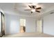 A bright main bedroom showing a ceiling fan, neutral carpet, and doors to closet and en-suite bathroom at 563 Copperdale Ave, Winter Garden, FL 34787
