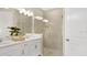 Modern bathroom showcasing double sinks, contemporary fixtures, and a glass-enclosed shower for a spa-like experience at 5646 Ficus Aurea St, Kissimmee, FL 34758