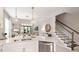 Open-concept kitchen featuring stainless steel appliances, sleek countertops, and stairs leading to upper floors at 5646 Ficus Aurea St, Kissimmee, FL 34758