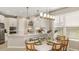 Bright kitchen with white cabinetry, stainless steel appliances, and an adjacent dining area with decorative lighting at 5646 Ficus Aurea St, Kissimmee, FL 34758