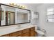 Bathroom with wood cabinets, white countertop, and a large framed mirror at 7602 Glenmoor Ln, Winter Park, FL 32792