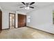 Carpeted bedroom featuring a ceiling fan, closet with louvered doors, and natural light at 7602 Glenmoor Ln, Winter Park, FL 32792