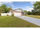 View of single Gathering home on a sunny day showcasing brick accents, manicured lawn and a two car garage at 7602 Glenmoor Ln, Winter Park, FL 32792