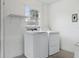 Well-lit laundry room features a washer, dryer, storage shelf, and window at 7602 Glenmoor Ln, Winter Park, FL 32792