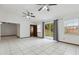 Spacious living room features white tile flooring, ceiling fans, and sliding glass doors to the backyard at 7602 Glenmoor Ln, Winter Park, FL 32792