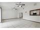 Open living area with tile flooring, ceiling fans, and a pass-through window to the adjacent kitchen at 7602 Glenmoor Ln, Winter Park, FL 32792