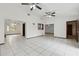 Bright living room boasts white tile flooring and multiple ceiling fans for a cool, airy feel at 7602 Glenmoor Ln, Winter Park, FL 32792