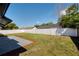 Wide view of the private backyard featuring a patio area, lush grass, and a white fence at 8143 Britt Dr, Orlando, FL 32822