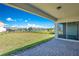 Covered patio with backyard view of a beautiful pond surrounded by a lush green lawn at 13231 Panama Beach Ct, Orlando, FL 32827