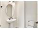 Powder room featuring a pedestal sink, modern faucet, and an elongated toilet at 13231 Panama Beach Ct, Orlando, FL 32827