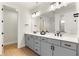 Modern bathroom features a double sink vanity with grey cabinets and a large mirror with decorative lighting at 13231 Panama Beach Ct, Orlando, FL 32827