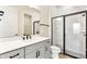 Bathroom with white vanity, black hardware, toilet, and glass shower with marble tile surround at 13231 Panama Beach Ct, Orlando, FL 32827