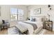 Staged bedroom featuring a large window, bed with nightstands, bench, and a modern area rug at 13231 Panama Beach Ct, Orlando, FL 32827