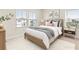 Bright bedroom features two windows, neutral walls, and a cozy bed with decorative pillows and side tables at 13231 Panama Beach Ct, Orlando, FL 32827