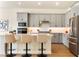 Modern kitchen features gray cabinets, stainless steel appliances, and a breakfast bar with three stools at 13231 Panama Beach Ct, Orlando, FL 32827