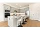 Contemporary kitchen with grey cabinets, stainless appliances, island with seating, and wood-look floors at 13231 Panama Beach Ct, Orlando, FL 32827
