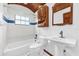 Cozy bathroom featuring a tub with tiled walls, a pedestal sink, and traditional fixtures at 1626 Wood Duck Dr, Winter Springs, FL 32708