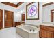 Elegant bathroom featuring a large tub with jets, dual sinks, and custom cabinetry at 1626 Wood Duck Dr, Winter Springs, FL 32708