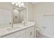 Bathroom featuring double sinks, solid countertops, and a tiled shower at 1755 Waterview Dr, Leesburg, FL 34748