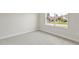 Bright bedroom features neutral walls, plush carpeting, and a large window offering neighborhood views at 1755 Waterview Dr, Leesburg, FL 34748