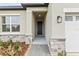 Inviting front entrance with stone accents, a covered porch, and a well-lit pathway to a modern black front door at 1755 Waterview Dr, Leesburg, FL 34748
