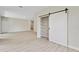 Open living room with wood-look flooring and a closet with sliding barn door at 1755 Waterview Dr, Leesburg, FL 34748