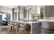 A modern kitchen boasts a marble island with seating and designer pendant lighting at 1910 Glencoe Rd, Winter Park, FL 32789