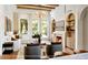 Bright living room with fireplace, custom built-ins, wood beam ceiling, and large windows at 1910 Glencoe Rd, Winter Park, FL 32789