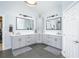 A serene bathroom boasts dual vanities, modern fixtures, and sleek tile flooring for a luxurious retreat at 4469 Old Bear Run, Winter Park, FL 32792