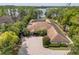 Aerial view of a sprawling home on the lake surrounded by lush landscaping and a brick driveway at 4469 Old Bear Run, Winter Park, FL 32792