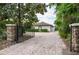 Private gated entrance with stone pillars enhances the property's exclusivity and security, along with a long brick driveway at 4469 Old Bear Run, Winter Park, FL 32792