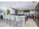 Gourmet kitchen featuring custom cabinets, stainless appliances, white countertops, island with wine storage, and skylight at 4469 Old Bear Run, Winter Park, FL 32792