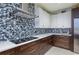 Modern kitchen featuring mosaic tile backsplash, stainless hood, cooktop, and white countertops at 4469 Old Bear Run, Winter Park, FL 32792