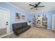 Inviting living room featuring a comfortable futon, stylish shelving, and soft carpet at 4469 Old Bear Run, Winter Park, FL 32792