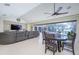 Open-concept living room with tile floors, dining area, large sectional sofa and access to a screened-in outdoor patio at 4469 Old Bear Run, Winter Park, FL 32792