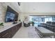 Modern living room featuring a large television, comfortable seating, and sliding glass doors to the outdoor pool area at 4469 Old Bear Run, Winter Park, FL 32792